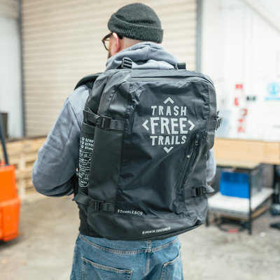 Trash free trails bag on a mans back. The bag has a trash free logo on the front.